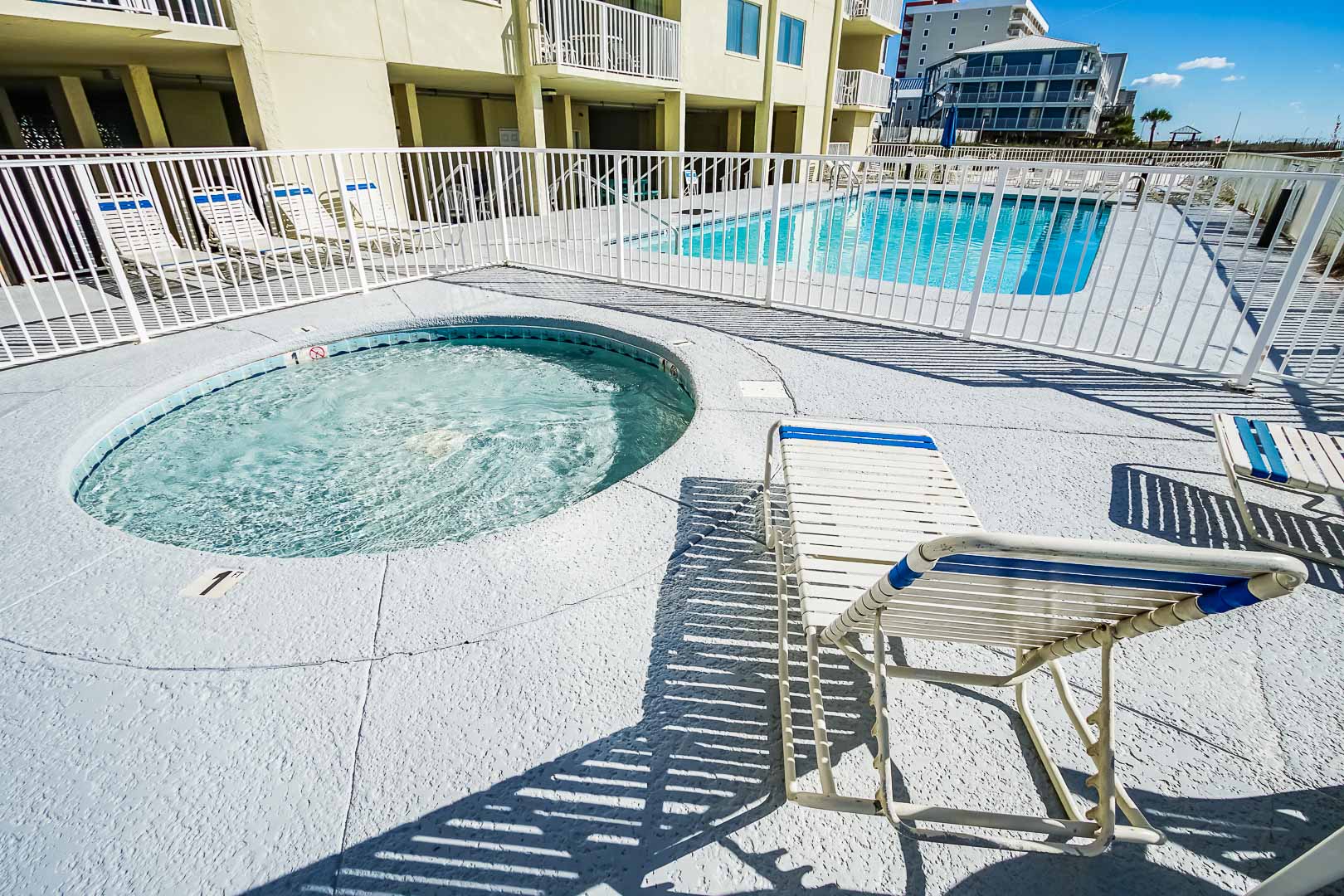 A peaceful outdoor swimming pool and Jacuzzi at VRI's Shoreline Towers in Gulf Shores, Alabama.